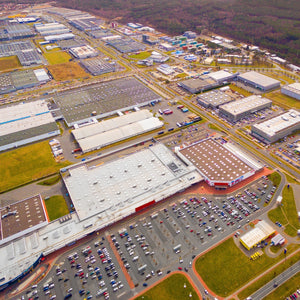 <Aerial overhead view of a large dietary supplement manufacturing facility with various buildings, car parks and green areas. Credit> AdobeStock_199347033