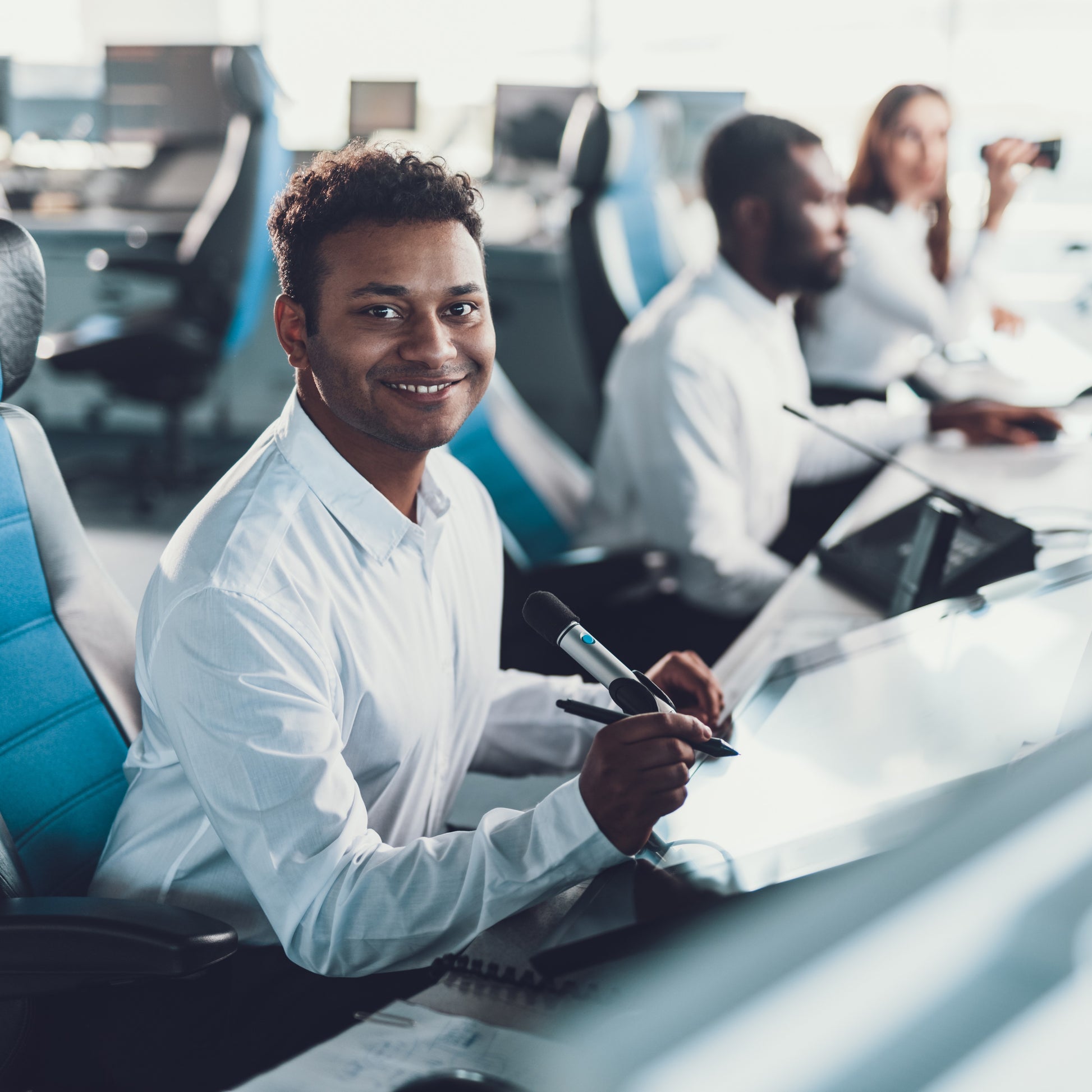 <Two male and one female employees sat at desks in a customer service call centre taking complaints and customer orders by phone. Credit> AdobeStock_243123859