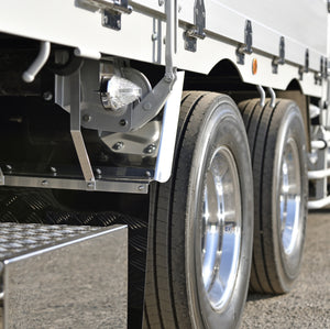 <Middle two chrome wheels, step entry and part of the white container of a lorry in the tarmac yard of a dietary supplement facility to distribute finished product. Credit> AdobeStock_247941076