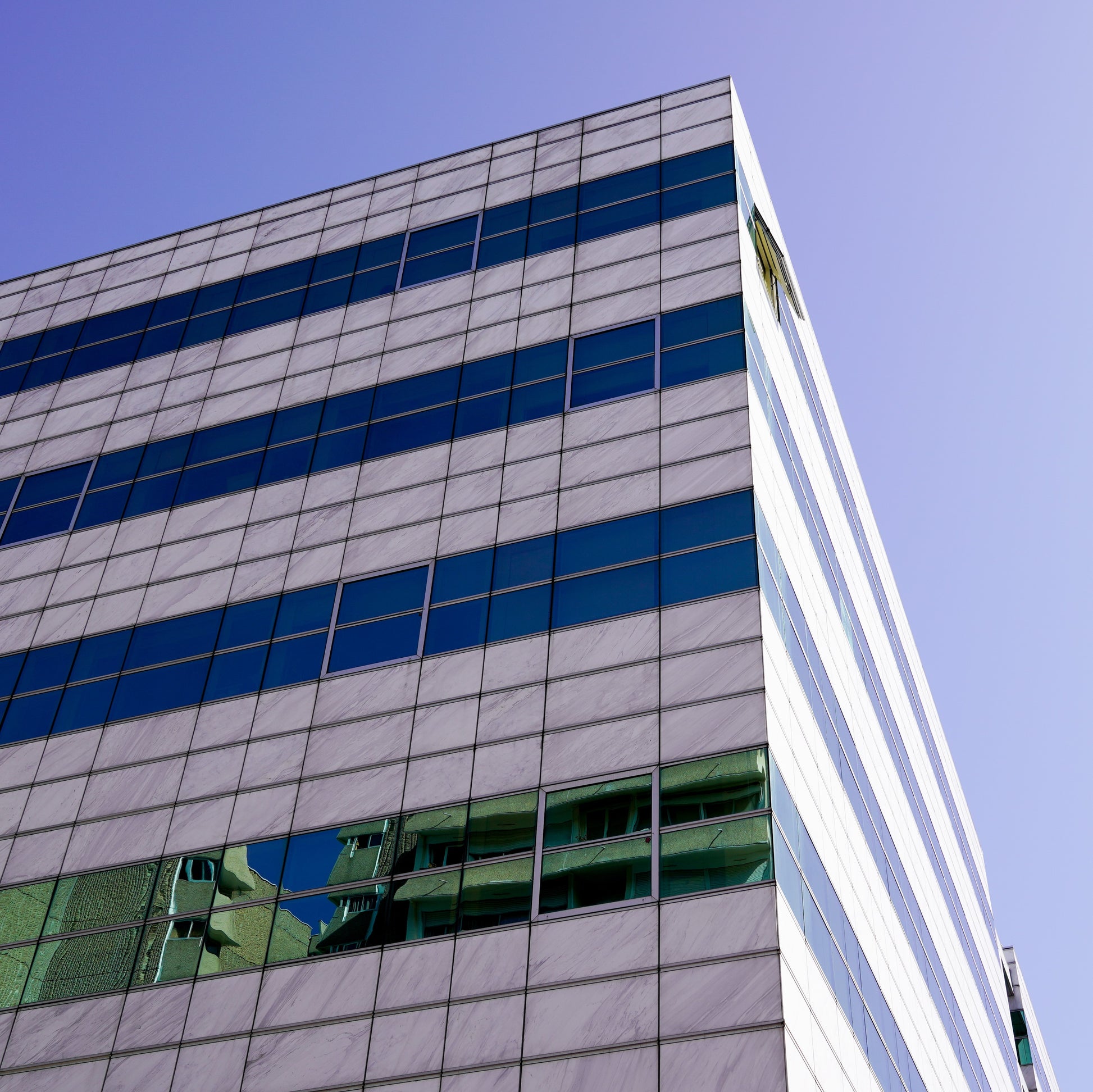 <Outside corner  of a modern silver, blue and glass striped laboratory building on a bright sunny day. Credit> AdobeStock_291035917