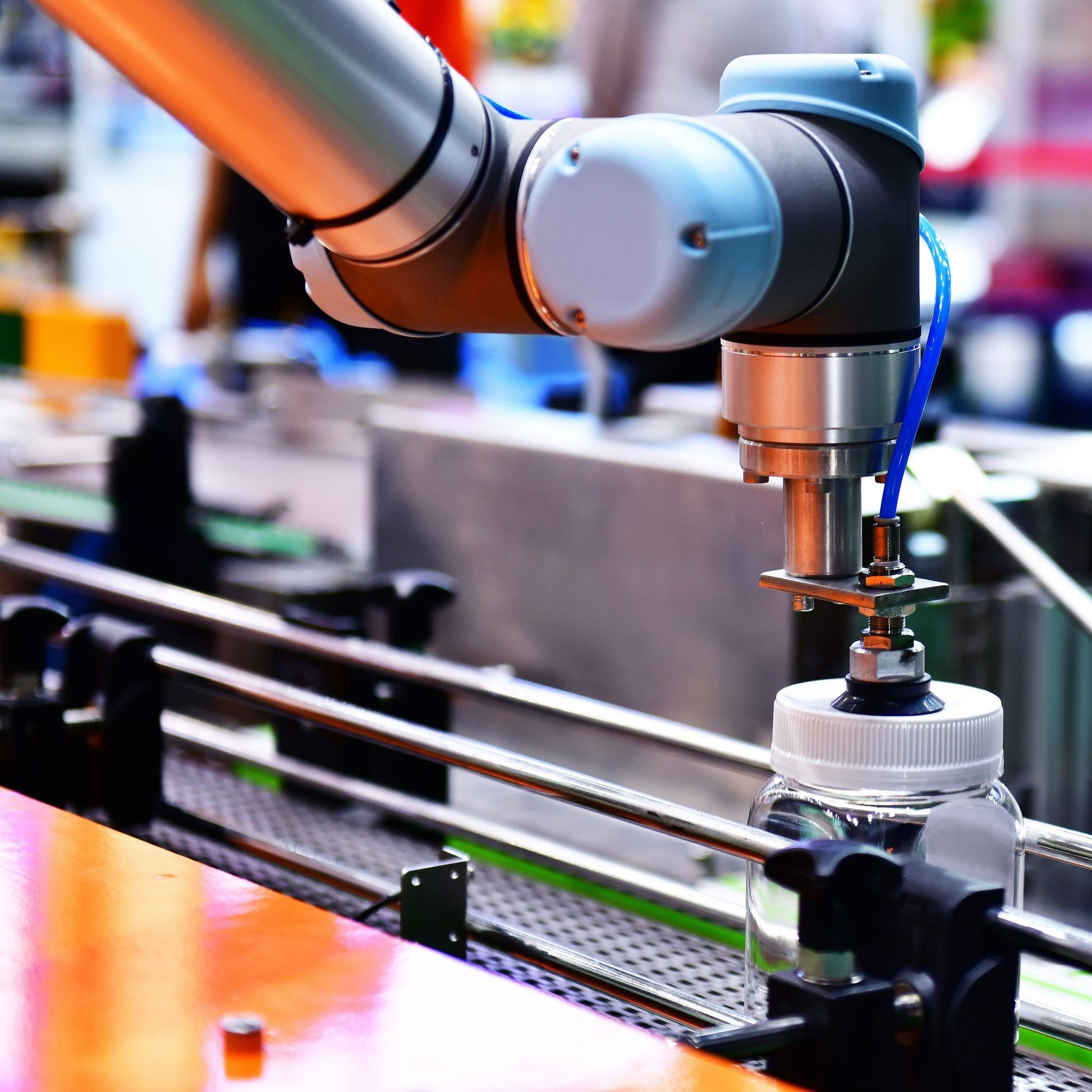 <An ink jet coder arm on a production line being fed from a plastic bottle of black ink for spraying the batch number and expiry date on the bottle, tube or vial. Credit> AdobeStock_326360926