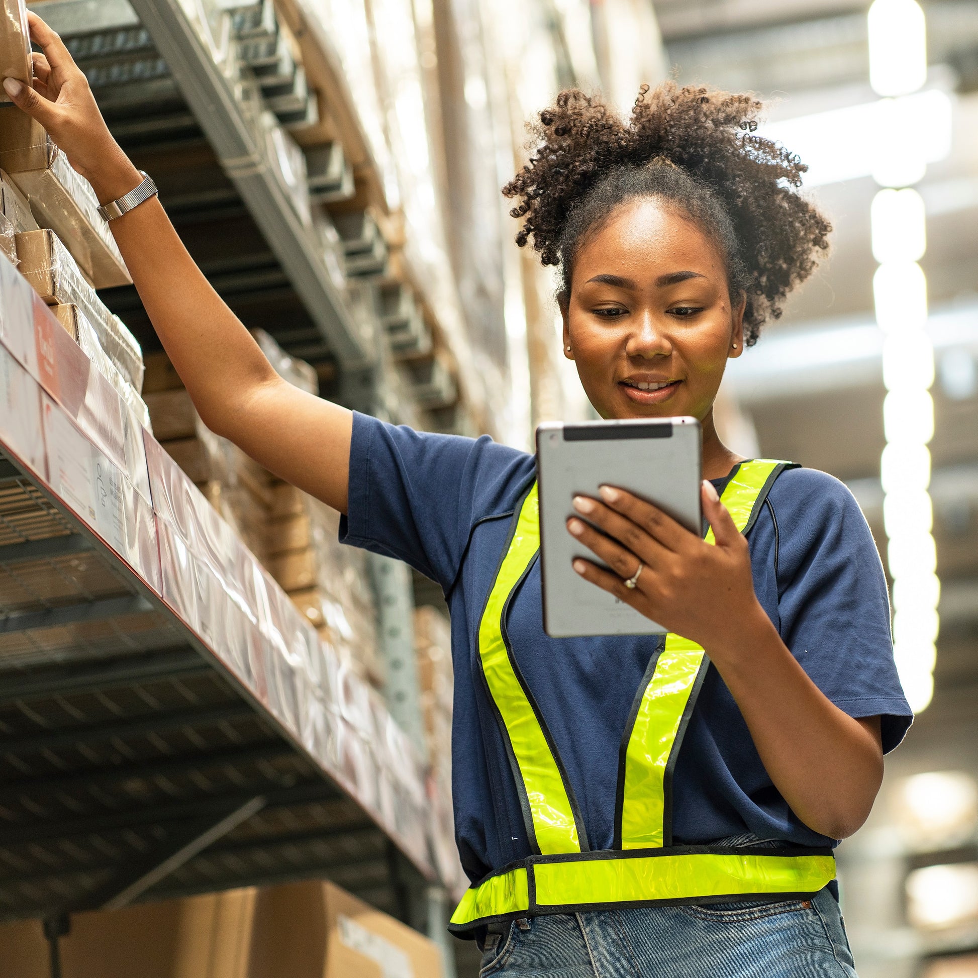 <Smily female warehouse operator checking the location of drug labels on a tablet. Credit> AdobeStock_534248242