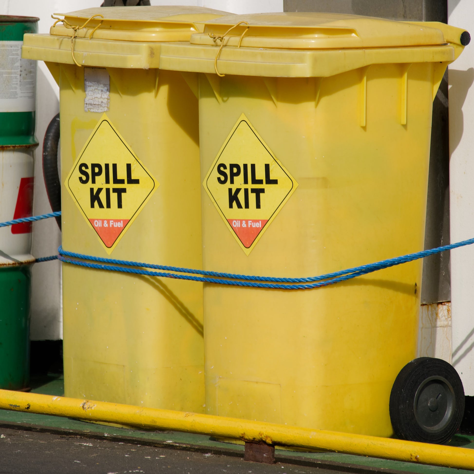 <Two yellow wheelie bins containing Spill Kits for containing spillages from lorries in the yard of a dietary supplement facility. Credit> AdobeStock_616771042