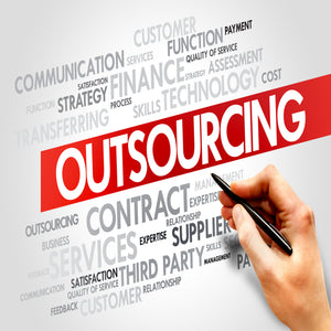 <Hand holding a pen pointing to a printed poster with word Outsourcing  in white on a red banner diagonally in the centre, with all aspects of outsourcing in grey or black outside it such as contract, strategy, expertise, satisfaction etc. Credit> AdobeStock_76373550