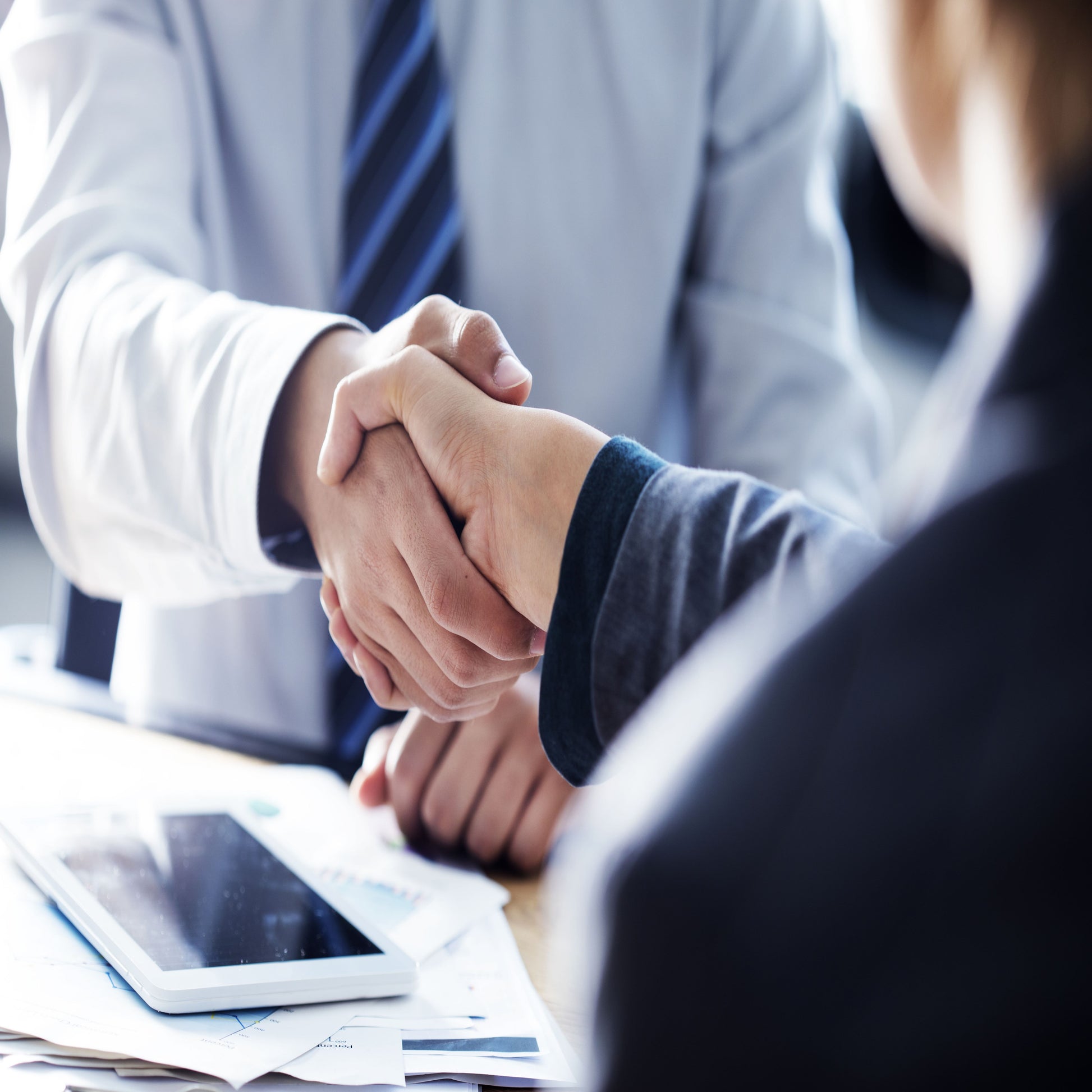 <Two men at a meeting room table shaking hands on an agreed supplier contract. Credit> 101469969 © Sebnem Ragiboglu | Dreamstime.com