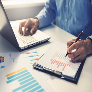 <Male QA officer at a laptop on a desk by the window, reviewing trends in graphs as part of the product quality review. Credit> 120496762 © Ronstik | Dreamstime.com