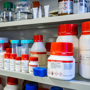 <Shelves of laboratory reagents, mainly in red and white bottles from Sigma Aldrich, being inspected for adequate control of. Credit> 346542643 © Forance | Dreamstime.com