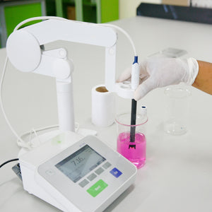 <White digital pH meter on a white lab worktop with an analyst wearing a glove holding the black probe in a glass beaker of purple coloured, clear liquid and getting a reading of pH 7.16. Credit> 95223342
© Puntasit Choksawatdikorn
| Dreamstime.com